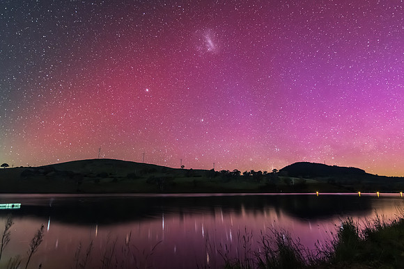 Aurora Australis display lights up the sky in pinks over the dam
