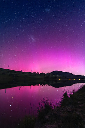 Aurora Australis display lights up the sky in pinks over the dam