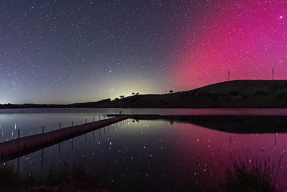 Aurora Australis display lights up the sky in pinks over the dam