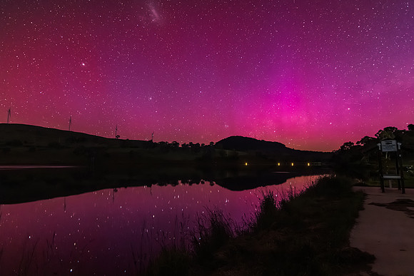 Aurora Australis display lights up the sky in pinks over the dam
