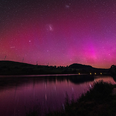 Aurora Australis display lights up the sky in pinks over the dam
