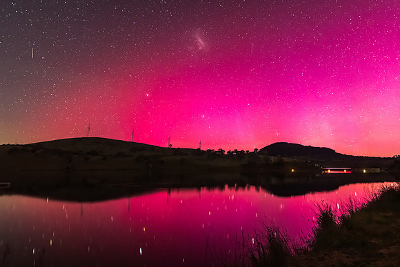 Aurora Australis display lights up the sky in pinks over the dam