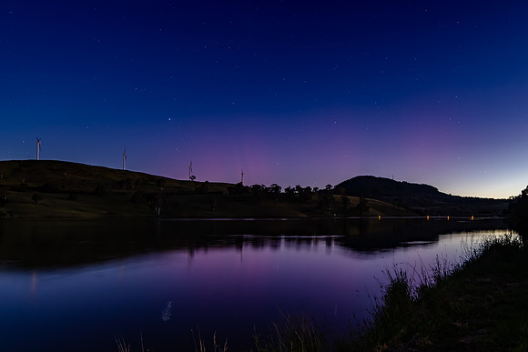 Aurora Australis display begins in the night sky with pink strea