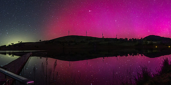 Aurora Australis display lights up the sky in pinks over the dam