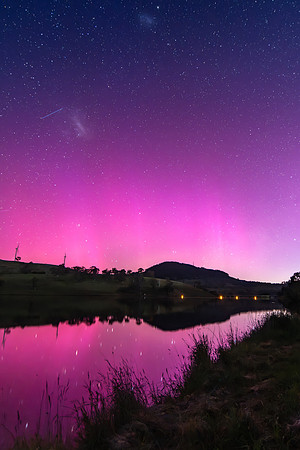 Aurora Australis display lights up the sky in pinks over the dam