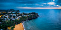 Aerial Sunrise Panorama at the Seaside with rain clouds, houses