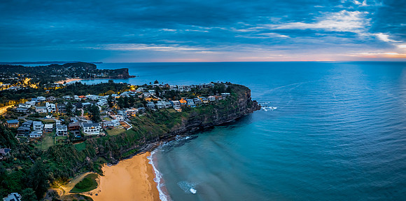 Aerial Sunrise Panorama at the Seaside with rain clouds, houses