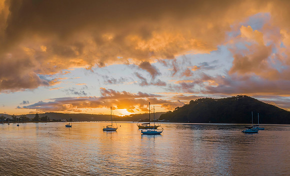 Aerial sunrise waterscape with boats and rain clouds