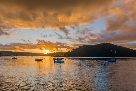 Aerial sunrise waterscape with boats and rain clouds