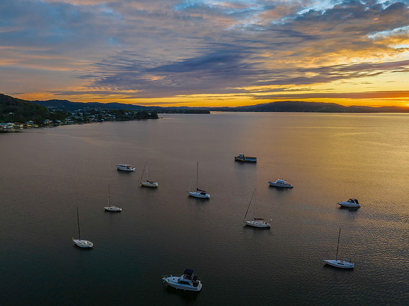 Aerial sunrise over the bay with boats and clouds