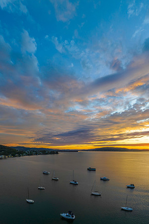 Aerial sunrise over the bay with boats and amazing clouds in the