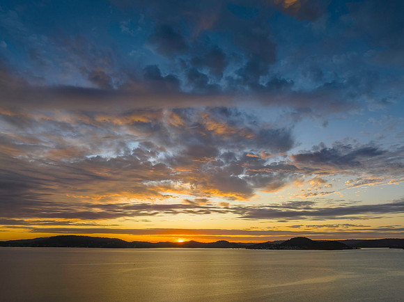 Aerial sunrise over the bay with boats and clouds