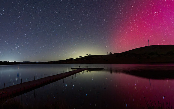Aurora Australis display lights up the sky in pinks over the dam