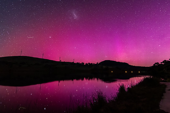 Aurora Australis display lights up the sky in pinks over the dam