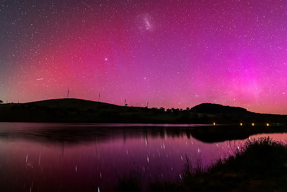 Aurora Australis display lights up the sky in pinks over the dam