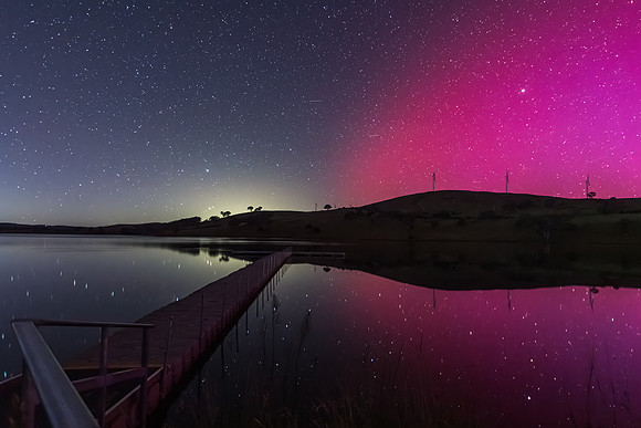 Aurora Australis display lights up the sky in pinks over the dam