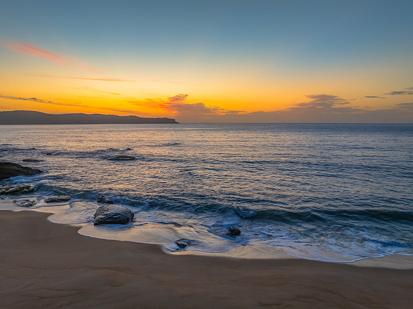Aerial sunrise at the seaside with light scattered high cloud an