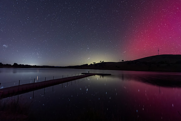 Aurora Australis display lights up the sky in pinks over the dam