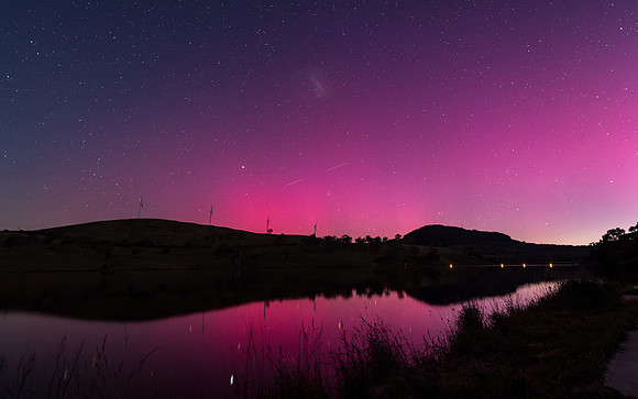 Aurora Australis display lights up the sky in pinks over the dam