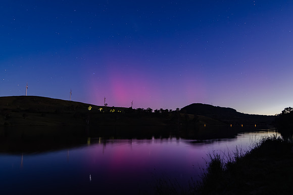 Aurora Australis display begins in the night sky with pink strea