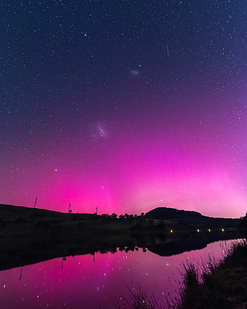 Aurora Australis display lights up the sky in pinks over the dam