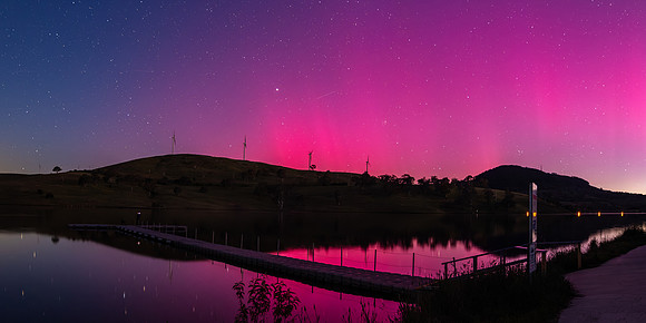 Aurora Australis display lights up the sky in pinks over the dam
