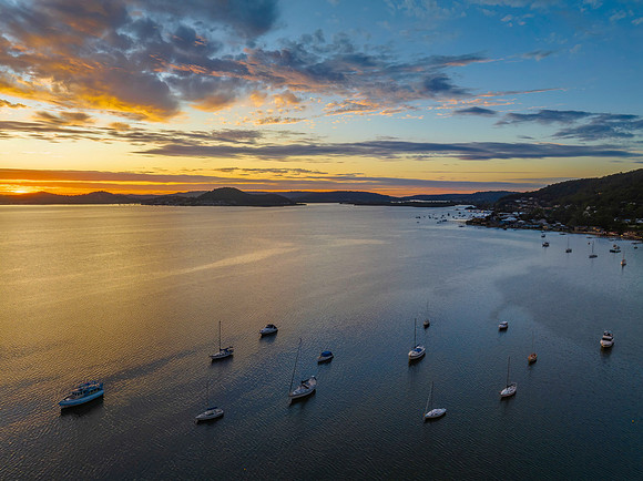 Aerial sunrise over the bay with boats and clouds
