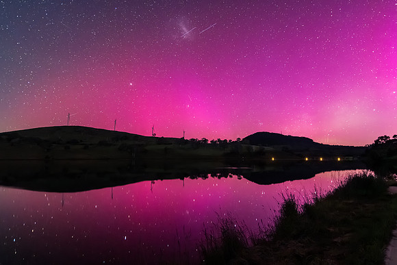 Aurora Australis display lights up the sky in pinks over the dam