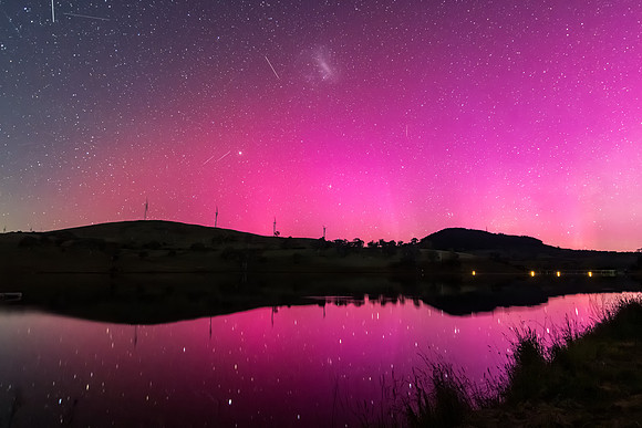 Aurora Australis display lights up the sky in pinks over the dam