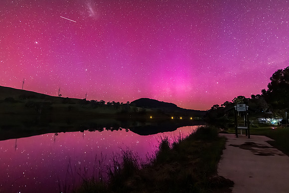 Aurora Australis display lights up the sky in pinks over the dam
