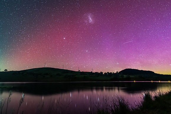 Aurora Australis display lights up the sky in pinks over the dam