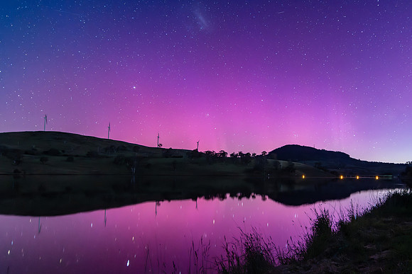 Aurora Australis display lights up the sky in pinks over the dam