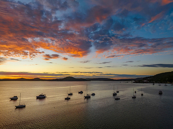 Aerial sunrise over the bay with boats and clouds