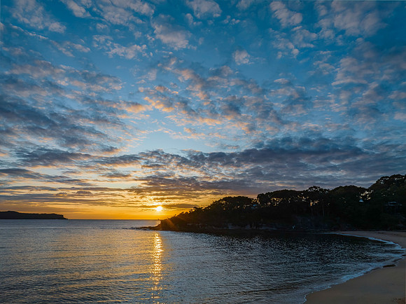 Aerial sunrise seascape with calm seas and a mix of low and medi