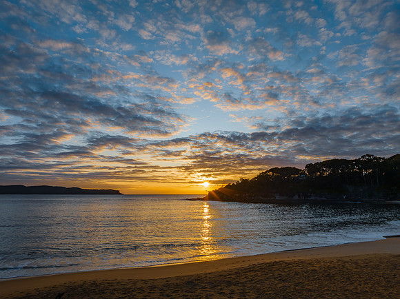 Aerial sunrise seascape with calm seas and a mix of low and medi