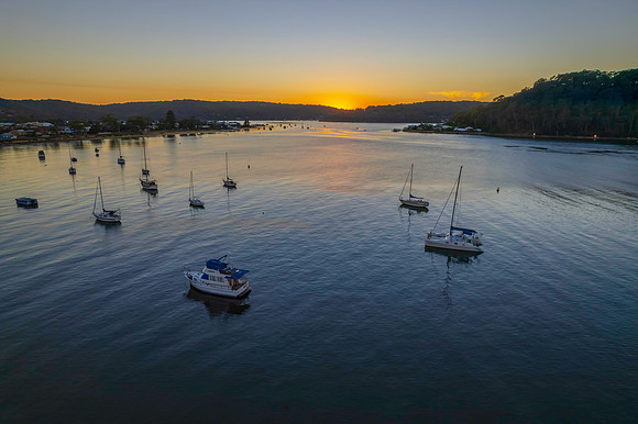 Aerial sunrise waterscape with boats and clear skies