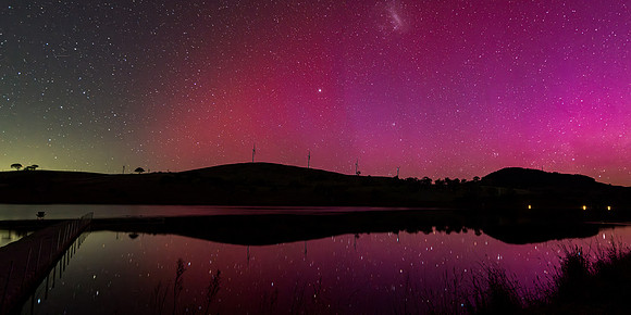 Aurora Australis display lights up the sky in pinks over the dam