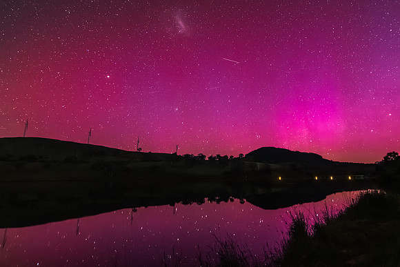 Aurora Australis display lights up the sky in pinks over the dam