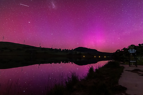 Aurora Australis display lights up the sky in pinks over the dam