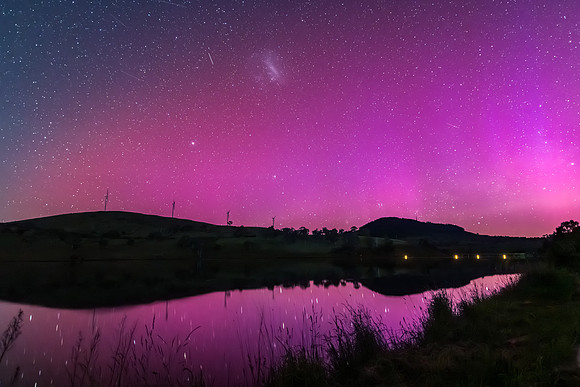 Aurora Australis display lights up the sky in pinks over the dam