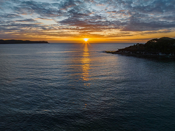 Aerial sunrise seascape with calm seas and a mix of low and medi