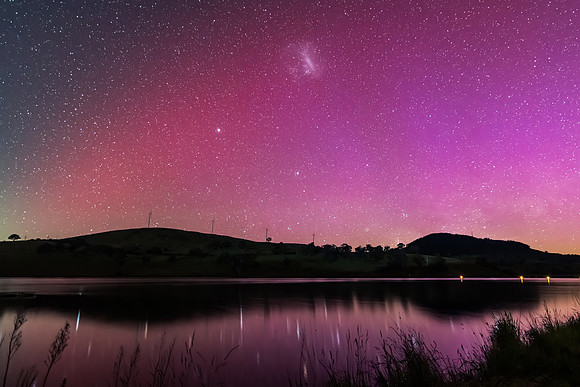 Aurora Australis display lights up the sky in pinks over the dam