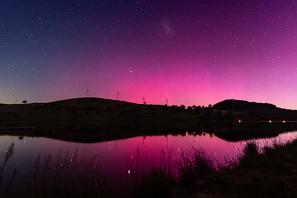Aurora Australis display lights up the sky in pinks over the dam