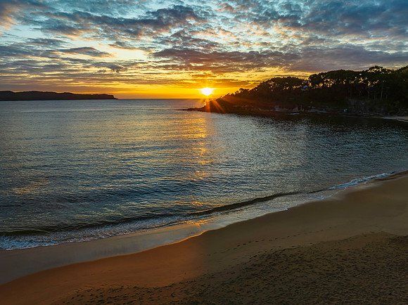 Aerial sunrise seascape with calm seas and a mix of low and medi