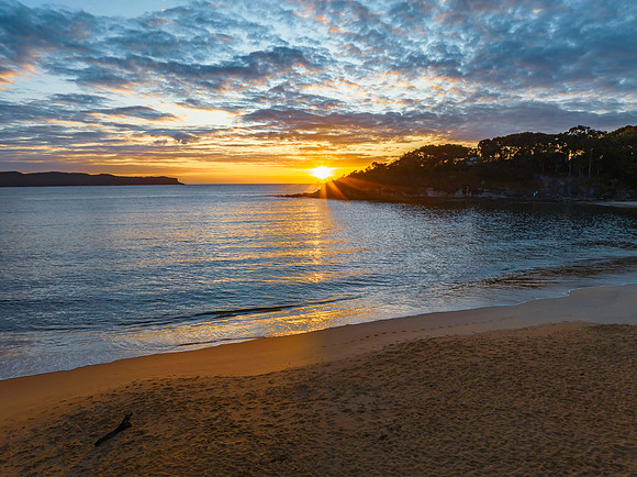 Aerial sunrise seascape with calm seas and a mix of low and medi