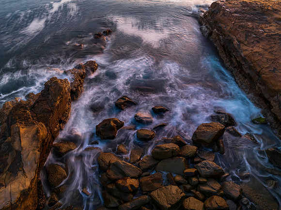 Top down sunrise over the ocean with rocks