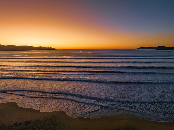 Clear skies aerial sunrise seascape with an orange glow