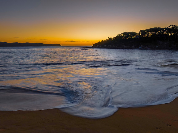 Aerial sunrise seascape with calm seas and a clear sky