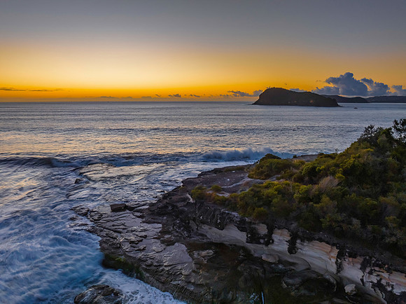 Aerial sunrise seascape with calm seas and a clear sky