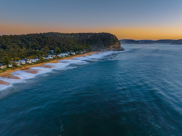 Aerial sunrise seascape with calm seas and a clear sky